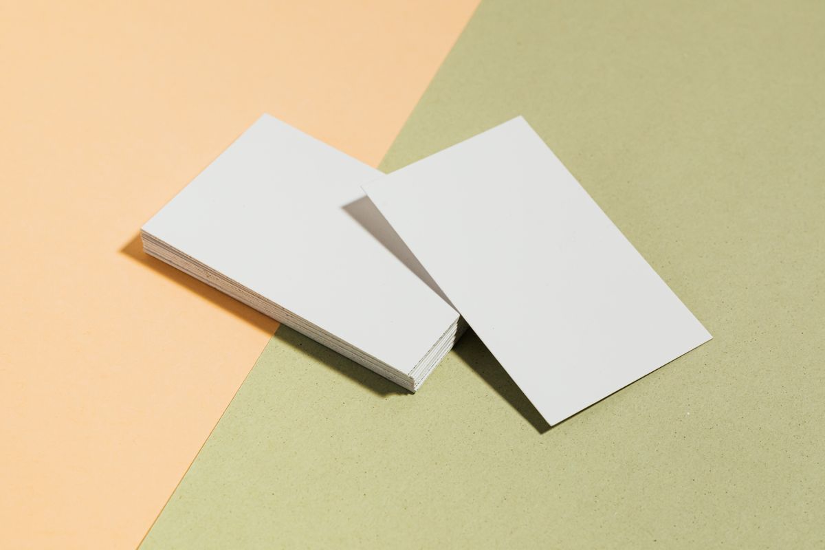 Stack of blank business cards on a colored surface